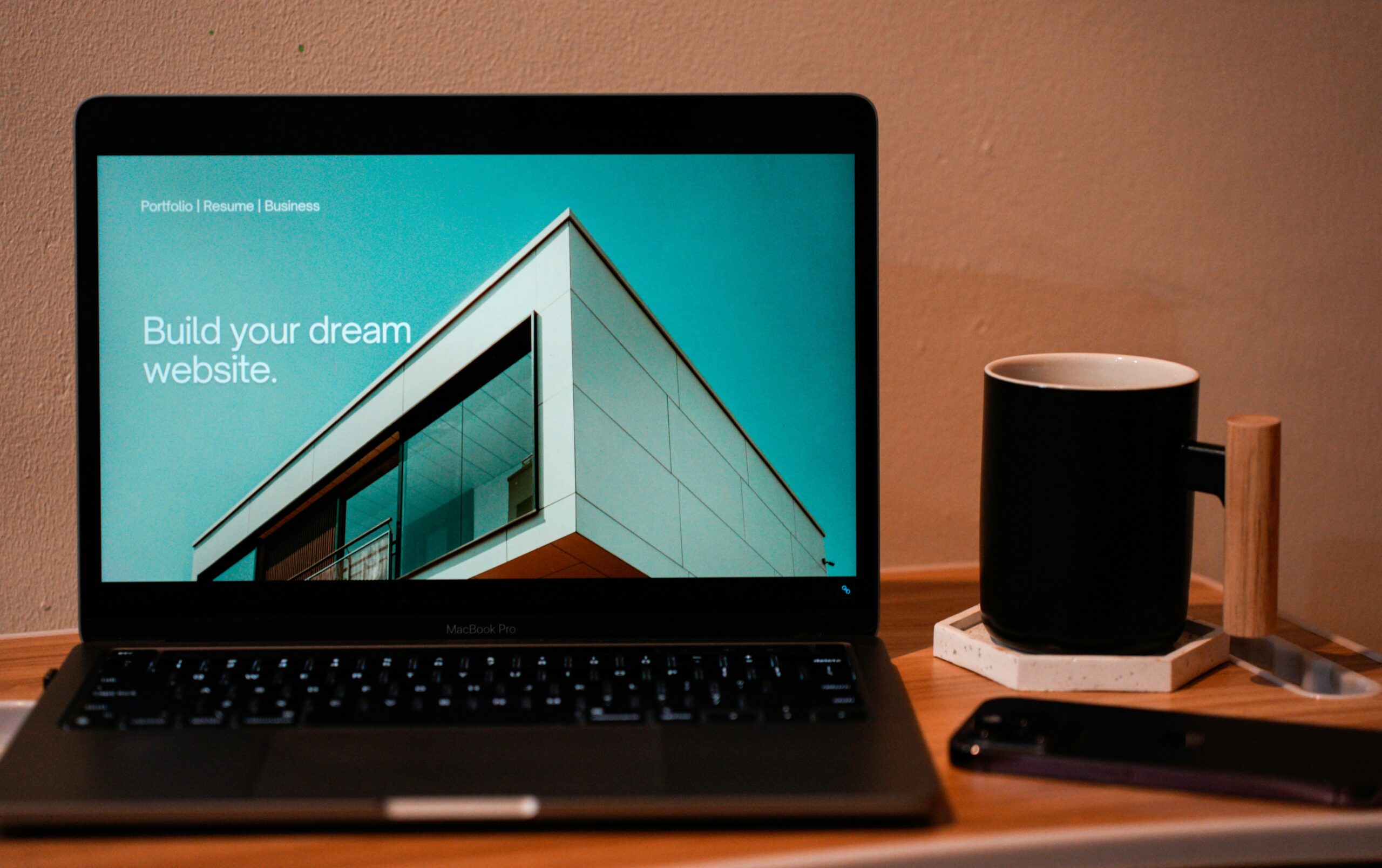 Website redesign: Laptop screen showing a promotional page with text "Build your dream website", next to a coffee cup and phone.